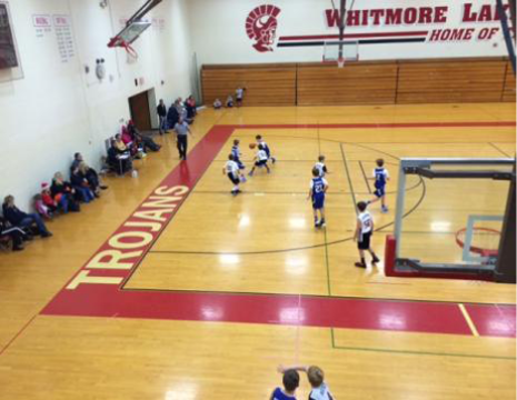 A basketball game taking place in the Whitmore Lake gymnasium.
