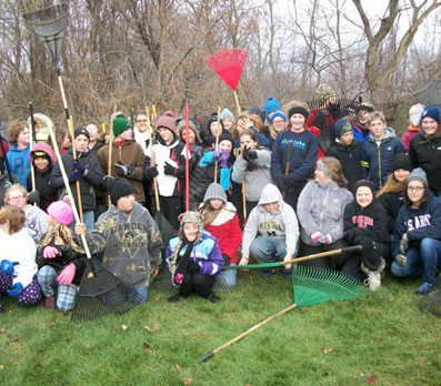 Photo of WLPS students in a group outside holding rakes.